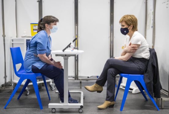 First Minister of Scotland Nicola Sturgeon (right) after receiving the first shot of the Astra Zeneca vaccine, administered by staff nurse Elaine Anderson, at the NHS Louisa Jordan vaccine centre in the SSE Hydro in Glasgow, Scotland. Picture date: Thursday April 15, 2021.