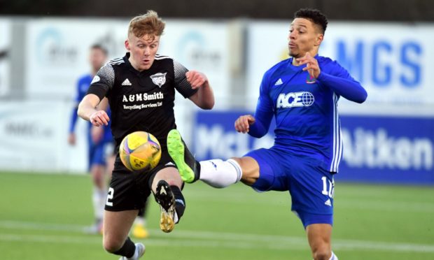 Cove's Leighton McIntosh and Peterhead's Andrew McCarthy jostle for possession.