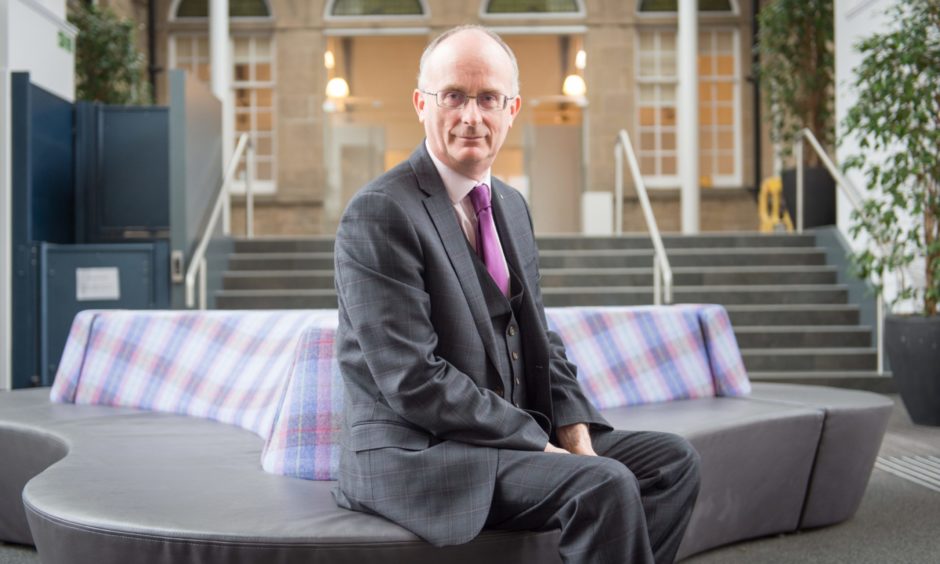 David Patterson sitting on chair inside main lobby of Moray UHI.