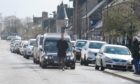 A procession of cars, shoppers and shopkeepers alike line the Alness High Street for the funeral of Craig Melville who died in a car accident