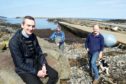 The Staffin slipway is to see a major expansion and improvement if plans go ahead. Staffin Community Trust Development Officer Hugh Ross while also in the photograph are fisherman and steering group member Ally MacDonald (oilskins) and trust director Calum Macdonald.