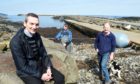The Staffin slipway is to see a major expansion and improvement if plans go ahead. Staffin Community Trust Development Officer Hugh Ross while also in the photograph are fisherman and steering group member Ally MacDonald (oilskins) and trust director Calum Macdonald.