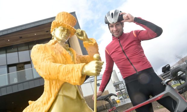 Mark Beaumont with the Johnnie Walker striding man statue at the Clynelish Distillery