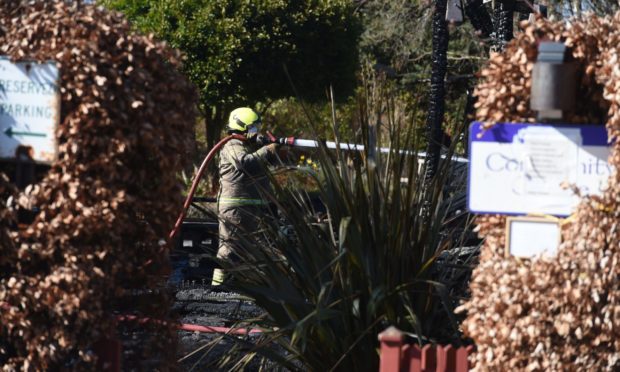 Firefighter extinguishing the hotspots at the blaze which destroyed the community centre