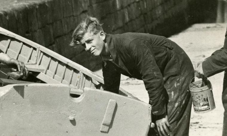 Prince Philip doing boat maintenance at Hopeman Harbour while a Gordonstoun pupil.