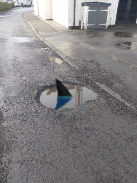 To go with story by Claire Warrender. Lewis Heaney has begun photoshopping potholes to draw attention to the problem Picture shows; Photoshopped potholes in St Monans. St Monans. Supplied by Lewis Heaney Date; Unknown; 3b91c93c-0e24-4c69-a4d1-33ad28f4c2d5