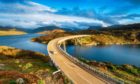 The Kylesku Bridge spanning Loch a' Chàirn Bhàin in the Scottish Highlands and a landmark on the North Coast 500 tourist driving route.