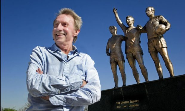 Denis Law stands in front of an already installed statue of himself at Old Trafford in Manchester