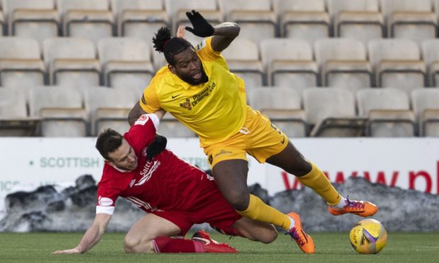 Andy Considine (L) of Aberdeen and Livingston's Jay Emmanuel-Thomas in action.