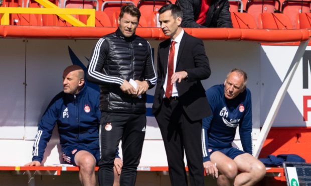 Aberdeen manager Stephen Glass talks with coach Allan Russell.