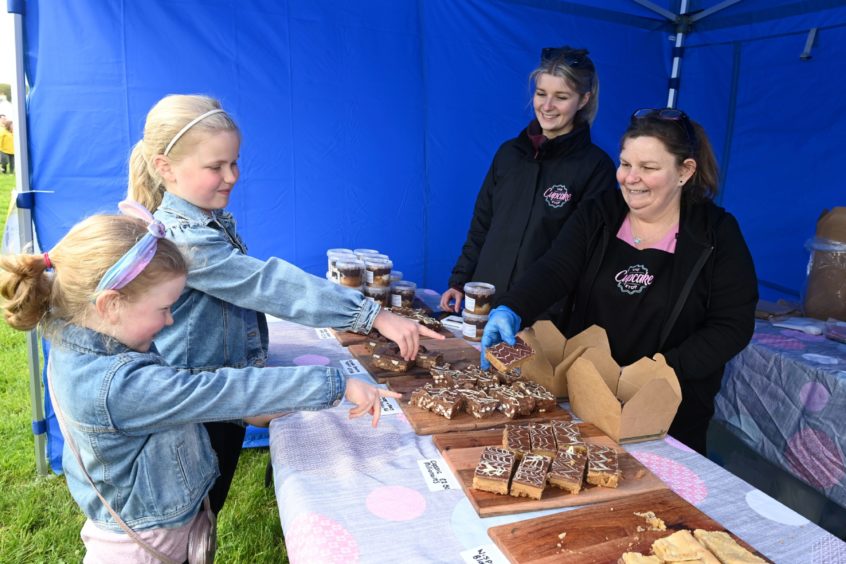 CR0028341
Food and Drink - Chapelton farmers' market at Burgess Park, Chapelton, Aberdeenshire.
Picture of sisters April, 6, and Beth Rollo, 9, at the The Cupcake Stop - Gemma Stephen and Jackie Stephen.

Picture by Kenny Elrick     23//2021