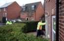 A Community safety patrol officer knocks on the door of a resident in Bramley Green, Hampshire, during a surge testing programme after a case of the South African variant of Covid-19 was identified in the village. Picture date: Wednesday February 17, 2021.