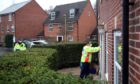 A Community safety patrol officer knocks on the door of a resident in Bramley Green, Hampshire, during a surge testing programme after a case of the South African variant of Covid-19 was identified in the village. Picture date: Wednesday February 17, 2021.