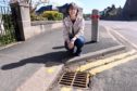 Councillor Sarah Dickinson with some of the fish decorated drains on Arduthie Road, Stonehaven. Pictured by Darrell Benns