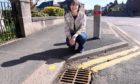 Councillor Sarah Dickinson with some of the fish decorated drains on Arduthie Road, Stonehaven. Pictured by Darrell Benns