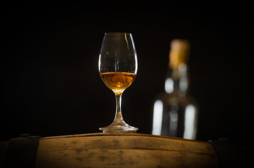 Whisky glass on barrel.