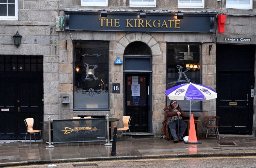 A man has a pint at The Kirkgate Bar in the rain.