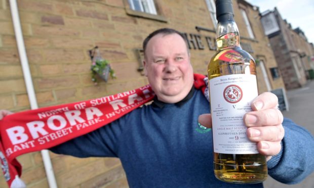 Eric De Venny, proprietor of the Eagle Hotel in Dornoch, with the special whisky that is helping raise cash for Brora Rangers. Picture by Sandy McCook