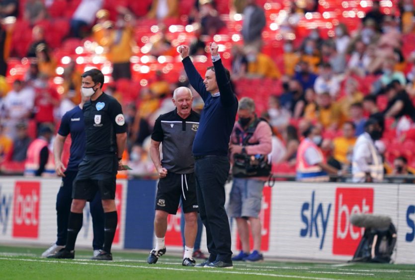 Morecambe manager Derek Adams celebrates on the touchline towards the end of the game during the Sky Bet League Two playoff final.