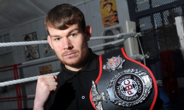 Aberdeen boxer Nathan Beattie holds up one of the title belts he has won during his career. Photo by Darrell Benns.