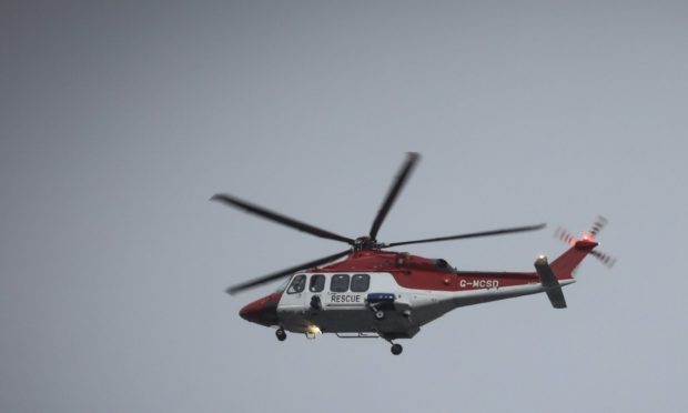 The Courier, No CR Number, News, Nadia Vidinova story, Extinction Rebellion activists vow to go down fighting as protesters scaled an oil rig at Dundee's port today. Picture shows; a rescue helicopter was seen as two activists scale the ladder on rig 'Valaris 122' Monday 6th January, 2020. Mhairi Edwards/DCT Media