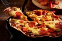 Tasty crispy oven-baked tortilla pepperoni pizza with spicy Italian sausage, melted cheese and tomato with a single slice being served in a restaurant, close up view; Shutterstock ID 503969227; 7a3cb517-0d6a-4fe0-8f79-2d2e628e0ffc