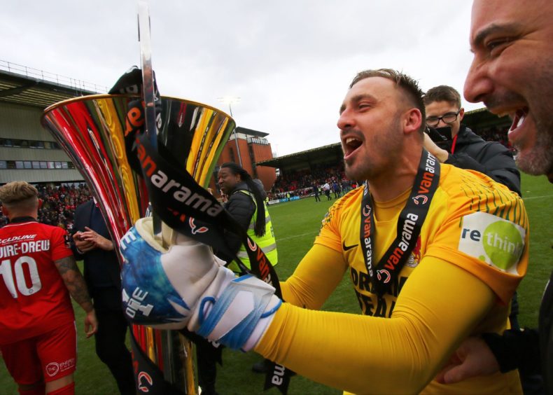 Leyton Orient goalkeeper Dean Brill celebrates with the Vanarama Trophy in 2019.