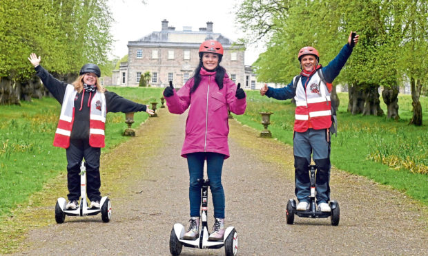 Gayle joins a Segway tour around Haddo Country Park run by Wheelie Fun. Pictured in front of Haddo House is Gayle, centre, flanked by company owners Claire and Merv Christie.