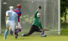Kingussie's Savio Genini lifts the ball over the Caberfeidh keeper Iain Macall to score.