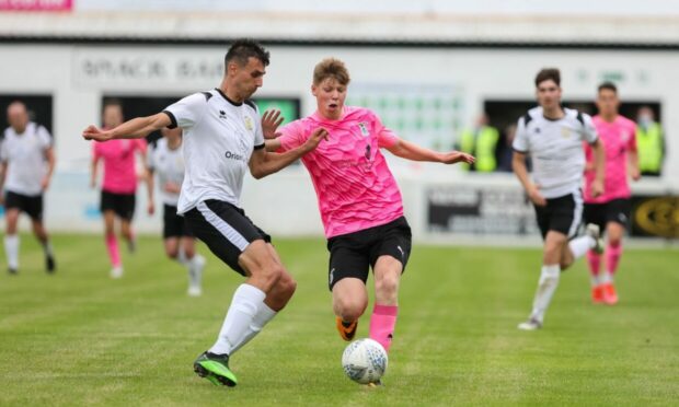 Clach's Michael McRobert, a summer signing from Loch Ness, competes for the ball in the midweek match against Caley Thistle.  Picture by Paul Campbell