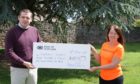 Dougals Ross handing over cheque to Sandra Mckandie from Keiran's Legacy.