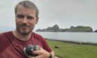 Conservationist Conor McKinney and the racing pigeon from Ireland nicknamed Declan he found on St Kilda.