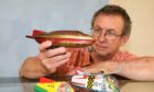Dave Smith of Bervie Auctions in Inverbervie with tin plate1950s space rockets