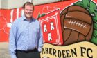 Aberdeen's commercial director Rob Wicks in front of some of the new artwork at Pittodrie