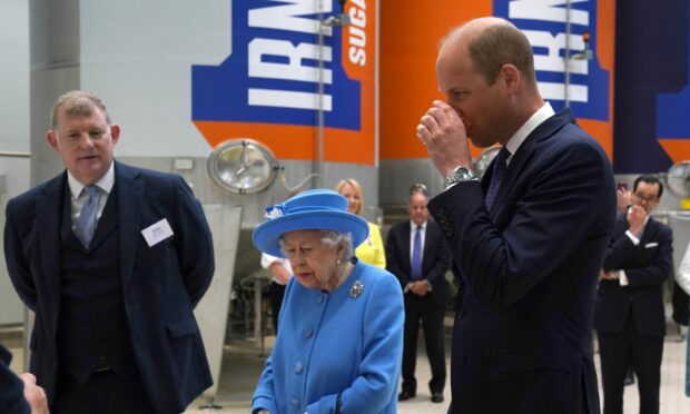 The Duke of Cambridge samples some Irn-Bru as The Queen looks on, during a visit to AG Barr's factory in Cumbernauld.
