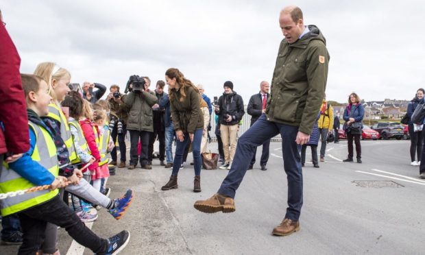 If the shoe fits: Prince William compares footwear and gets some style advice from children from Glaitness Nursey during a first royal visit to Orkney.