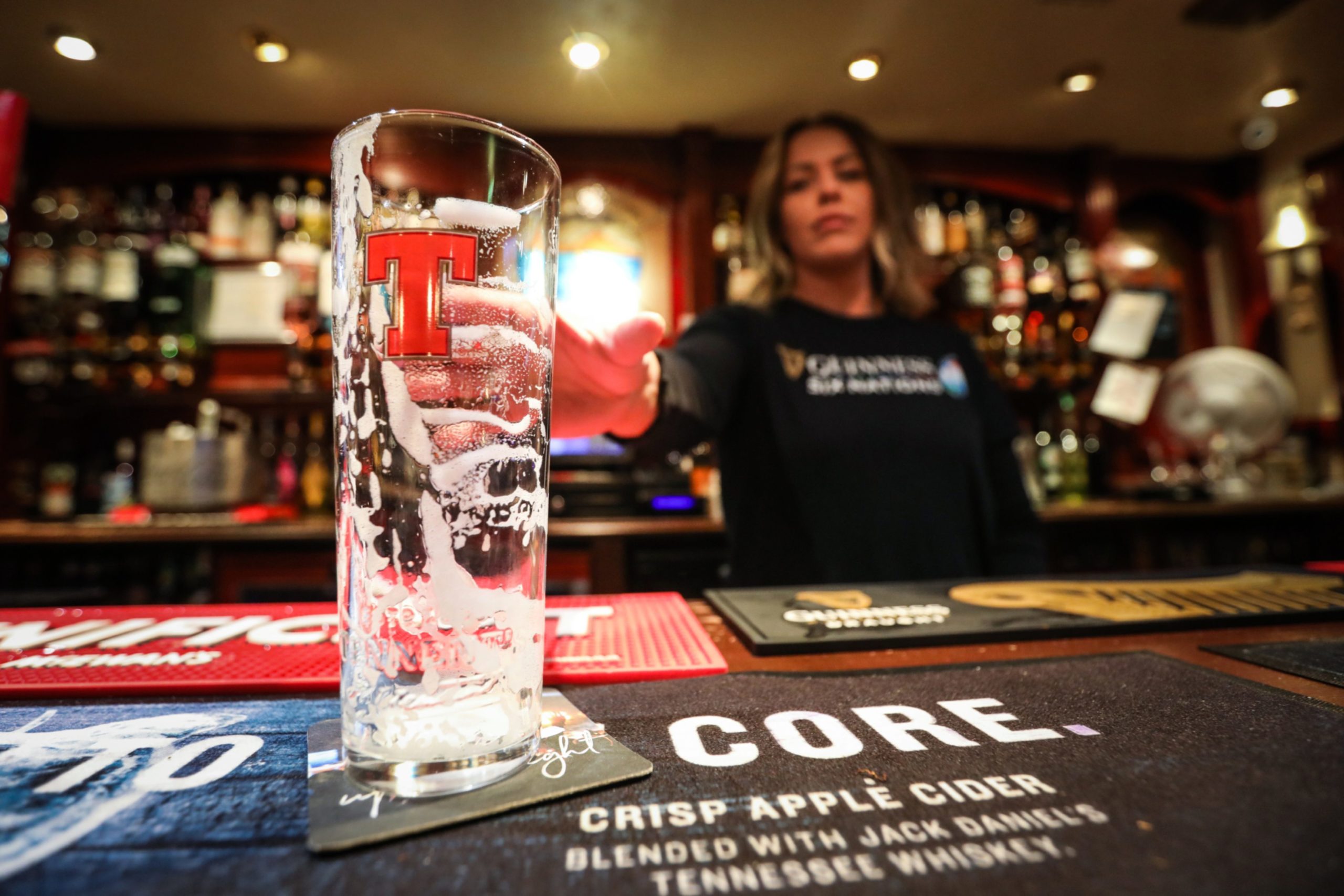 Empty Tennent's glass on the bar top.