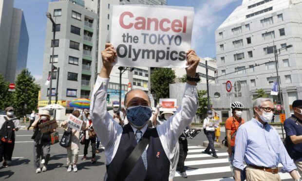 Anti-Olympics activists hold placards during a rally against the stay of the IOC President Thomas Bach in Tokyo.