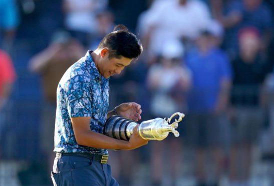 Collin Morikawa checks his name on the Claret Jug after his Open victory.