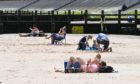 People enjoying the sun on Aberdeen beach.