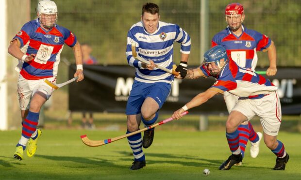 Newtonmore's Steven Macdonald is challenged by Kingussie's James Falconer in a Mowi Premiership tie from 2019.