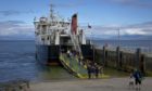 The MV Loch Nevis berthed at the Isle of Eigg with passengers disembarking.