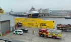 Firefighters are currently working to free a man from a confirmed space onboard an American offshore supply vessel.