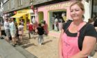 Business owner Rosanne Mackenzie as customers form a queue in the hot sun. Picture by Sandy McCook