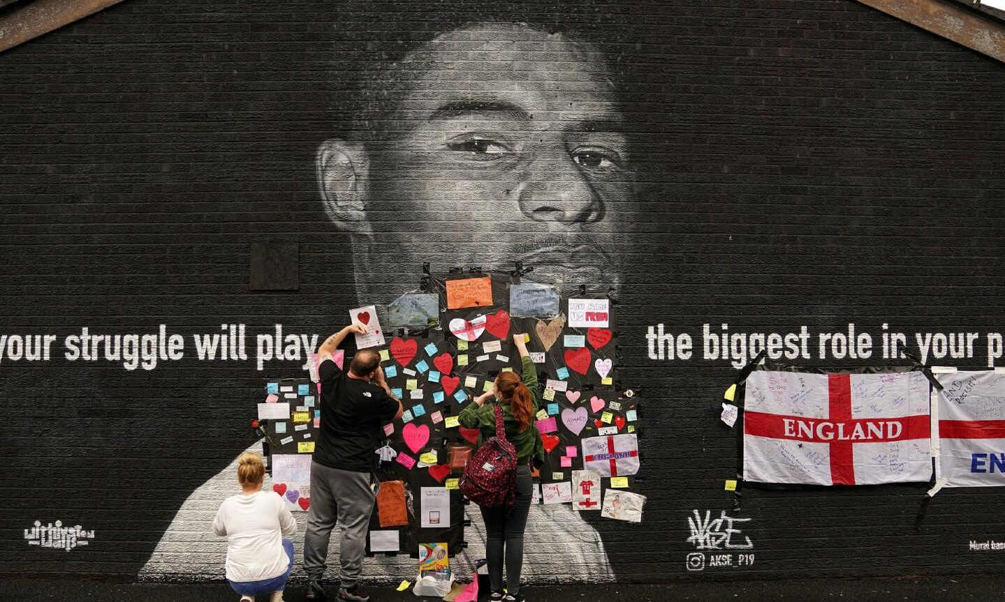 People place messages of support on top of bin liners that were taped over offensive wording on the mural of Manchester United striker and England player Marcus Rashford. Photo: Martin Rickett/PA Wire.