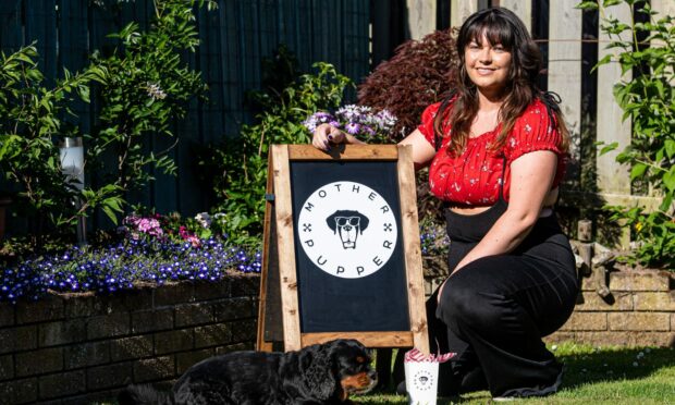 Toni Gordon of Mother Pupper vegan dog treats posing next to a company sign