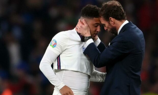 England football manager Gareth Southgate (right) comforts player Jadon Sancho