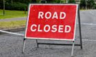 A red temporary "Road Closed" sign with police tape.; Shutterstock ID 1101681842; Purchase Order: -