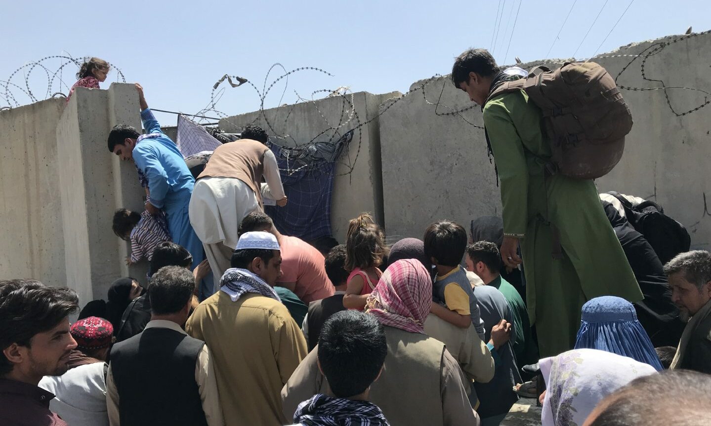Afghans trying to climb over walls