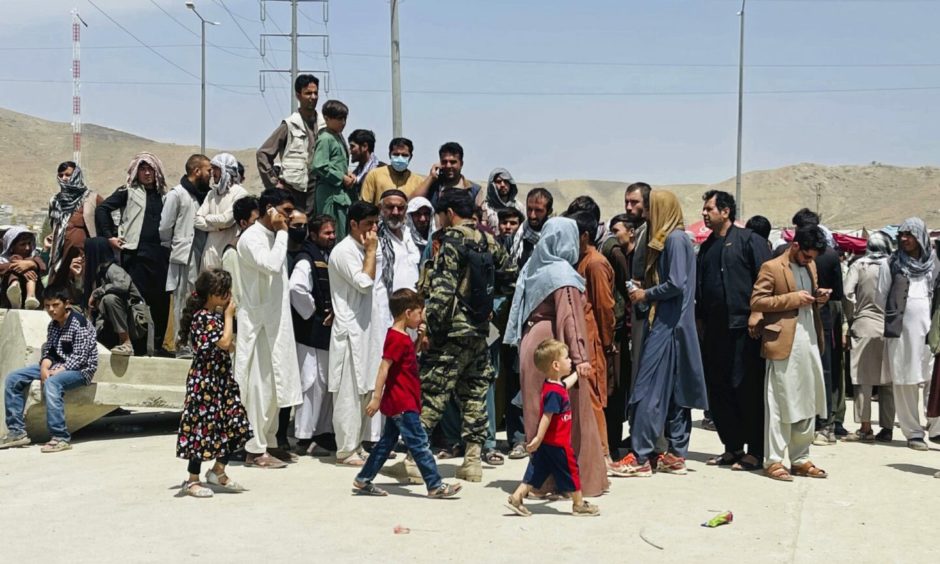 Hundreds of people gather outside the international airport in Kabul, Afghanistan on Tuesday, August 17.